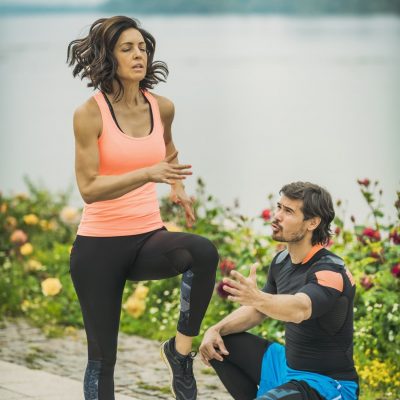 Female Exercising by the River with Personal Fitness Trainer