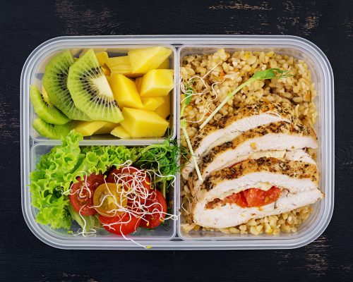 Lunch box chicken, bulgur, microgreens, tomato and fruit. Healthy fitness food.